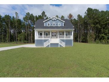 Charming home featuring a spacious porch, two stories, and a beautifully landscaped yard at 1329 Wood Sorrel Dr, Moncks Corner, SC 29461
