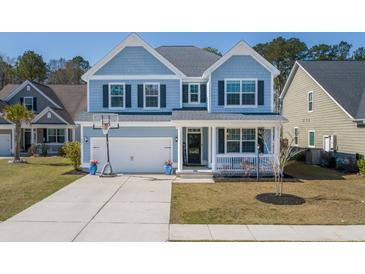 Charming two-story home with light blue siding, white trim and a well-manicured lawn at 221 Waning Way, Charleston, SC 29492