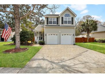 Charming home featuring a two-car garage, an American flag, and well-manicured landscaping at 3545 Rookwood Pl, Johns Island, SC 29455