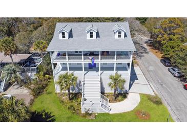 Beautiful three story home with double balconies, palm trees, and eye-catching curb appeal at 502 W Ashley Ave, Folly Beach, SC 29439