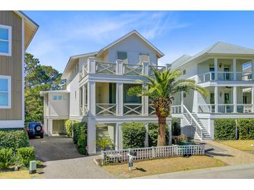 Charming, multi-story beach home featuring a quaint white picket fence, landscaped yard and cross beam railings at 744 Gate Post Dr, Mount Pleasant, SC 29464