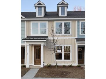 Charming townhouse featuring a black roof, dormer windows, and a light beige exterior with a covered entry at 143 Cantona Dr, Summerville, SC 29483