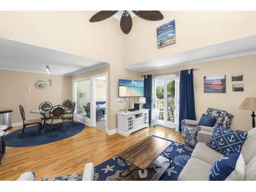 Bright living room with vaulted ceilings, hardwood floors, and beach-themed decor at 1638 Live Oak Park, Seabrook Island, SC 29455