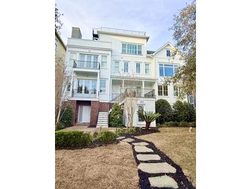 Stunning multi-story white home featuring dual balconies, meticulous landscaping, and a charming stepping stone walkway at 172 Mary Ellen Dr, Charleston, SC 29403