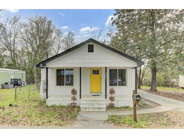 Charming bungalow with a bright yellow front door, black trim and a cozy front porch at 204 Delano St, Saint George, SC 29477