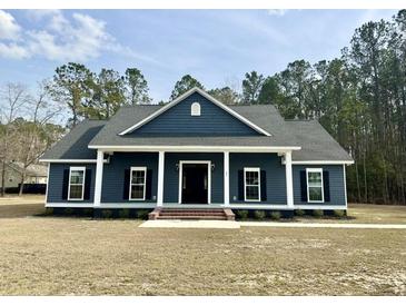 Charming single-story home with dark siding, white trim, shutters, and a welcoming front porch at 85 Prestwick Pl, Walterboro, SC 29488