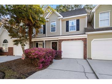 Charming townhome featuring a well-maintained lawn, mature landscaping and an attached one-car garage at 8741 Grassy Oak Trl, North Charleston, SC 29420