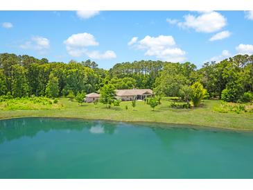 Stunning exterior view of home, featuring a serene pond and lush greenery at 1420 Polly Point Rd, Wadmalaw Island, SC 29487