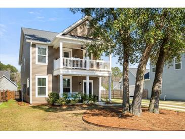 Charming two-story home featuring a double front porch, swing, and well-manicured lawn at 1532 Roustabout Way, Charleston, SC 29414