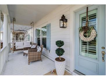 Inviting front porch featuring a swing, seating, stylish decor, and charming blue door at 1756 Timmons St, Mount Pleasant, SC 29466