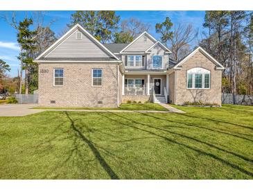 Charming two-story home with a well-manicured lawn and appealing brick and vinyl siding at 1880 Bacons Bridge Rd, Summerville, SC 29485