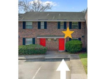 Brick townhouse featuring red doors and manicured landscaping at 2362 Parsonage Rd # 2G, Charleston, SC 29414