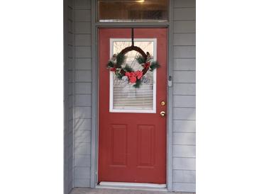 Charming red front door adorned with a festive holiday wreath and a modern doorbell camera system at 3406 Mariners Way, Moncks Corner, SC 29461
