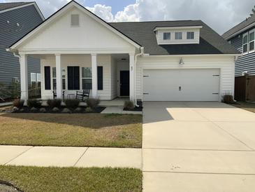 Charming one-story home featuring a covered porch, black shutters, and a two-car garage at 87 Morning Song St, Summerville, SC 29485