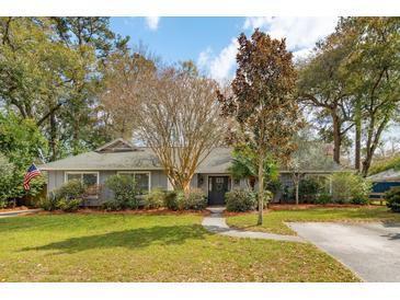 Charming home exterior features a well-manicured lawn, beautiful landscaping, and a welcoming entrance at 1327 Bob White Dr, Charleston, SC 29412