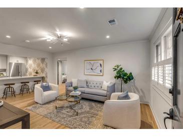 Bright living room featuring hardwood floors, recessed lighting, and stylish modern furnishings at 7 Logan St # F, Charleston, SC 29401