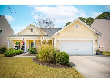 Charming yellow home with a well-manicured lawn and an attached two-car garage, creating a welcoming curb appeal at 7503 Hawks Cir, Hanahan, SC 29410