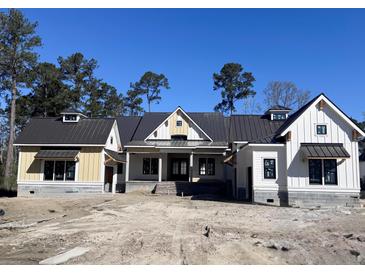 Charming new construction home featuring a metal roof and light yellow and white siding at 3945 Bulow Landing Rd, Hollywood, SC 29470
