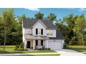 Charming two-story home with a welcoming front porch, attached garage, and nicely landscaped front yard at 1049 Tea Time Dr, Summerville, SC 29485