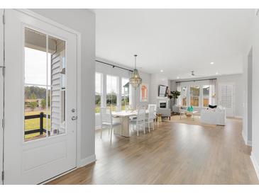 Bright, open-concept living and dining area with hardwood floors and modern decor throughout the space at 109 Marions Oak Dr, Summerville, SC 29486