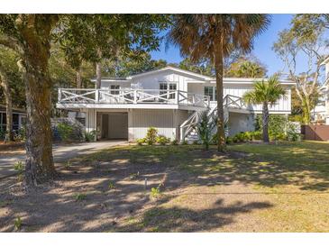 Charming two-story home boasts a wrap-around porch, lush landscaping, and a two-car garage at 29 27Th Ave, Isle of Palms, SC 29451