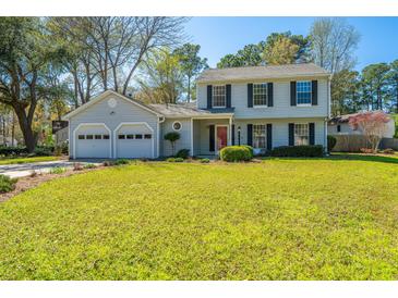 Charming two-story home with a well-maintained lawn and attached two car garage at 102 Challis Ct, Goose Creek, SC 29445