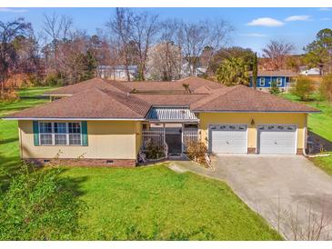 Charming one-story home featuring a manicured lawn and an attached two-car garage at 1117 Walleye Rd, Bonneau, SC 29431
