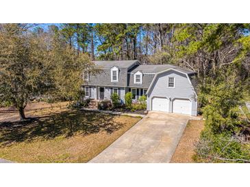 Charming two-story home with a well-manicured lawn, a two-car garage, and mature trees at 202 Hunt Club Dr, Summerville, SC 29485