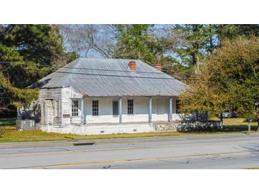 Charming single-story home featuring a covered front porch and a brick chimney, set on a tree-lined street at 2604 Highway 78, Dorchester, SC 29437