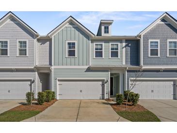 Charming townhome featuring colorful siding, a one-car garage, and manicured landscaping at 2901 Eddy Dr, Mount Pleasant, SC 29466