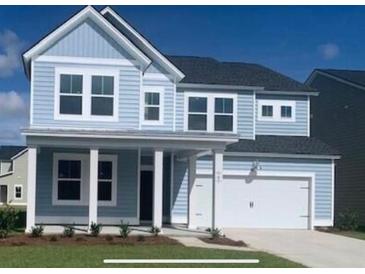 Charming two-story home with blue siding, a covered porch, and an attached garage offers curb appeal at 519 Verdi Dr, Summerville, SC 29486