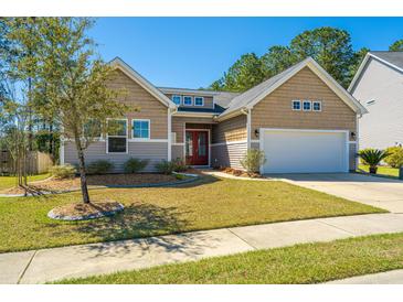 Charming home with a well-manicured lawn, a red front door and a two car garage at 718 Kilarney Rd, Summerville, SC 29483