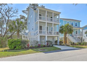 Charming three-story coastal home featuring double balconies, a lush yard, and a private garage at 824 Forrest Dr, Charleston, SC 29492