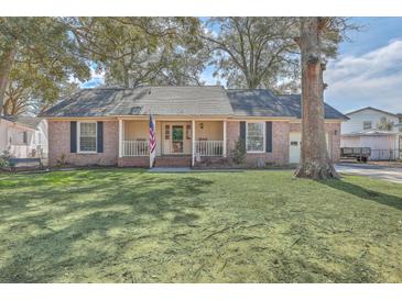Charming brick home with an inviting front porch, classic shutters, and a well-manicured lawn at 886 Piccadilly Cir, Charleston, SC 29412