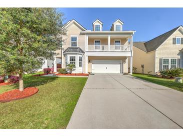 Charming two-story home with a covered porch and well-manicured lawn and driveway at 9988 Winged Elm St, Ladson, SC 29456