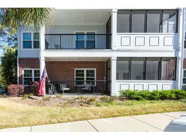 Charming condo with a screened porch, black metal railings, and an American flag at 1025 Riverland Woods Pl # 907, Charleston, SC 29412
