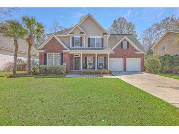 Charming two-story brick home with a well-manicured lawn, palm trees, and a two-car garage at 103 Sago Palm Ct, Summerville, SC 29483