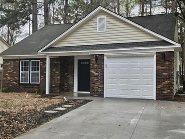 Charming one-story brick home featuring an attached garage and a well-manicured lawn at 212 Regent St, Summerville, SC 29483