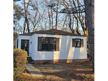 Charming single-story home featuring a well-maintained yard, black shutters and a welcoming front door at 2671 Houston St, North Charleston, SC 29405