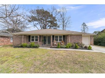 Charming brick home with a well-maintained front yard and a cozy front porch with rocking chairs at 303 Gippy Dr, Summerville, SC 29486