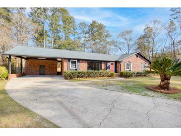 Charming brick home with a well-manicured lawn and driveway, showcasing its curb appeal at 313 Runnymede Ln, Summerville, SC 29485