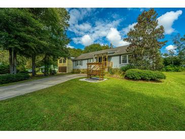Charming home featuring a well-manicured front yard, a swing, a long driveway and a detached two-car garage at 3596 Walter Drive Dr, Johns Island, SC 29455