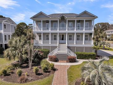 Stately two-story home with double porches and lush landscaping creating an inviting facade at 4922 Sound View Dr, Mount Pleasant, SC 29466