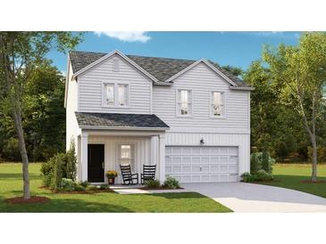 Charming two-story home featuring white siding, a covered porch with rocking chairs, and an attached garage at 577 Red Monarch Way, Moncks Corner, SC 29461