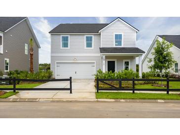 Charming two-story home with a black fence, a garage, and beautiful landscaping at 579 Red Monarch Way, Moncks Corner, SC 29461