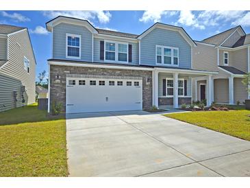 Charming two-story home featuring a gray shingle and stone exterior, a two-car garage, and a well-manicured lawn at 591 Red Monarch Way, Moncks Corner, SC 29461
