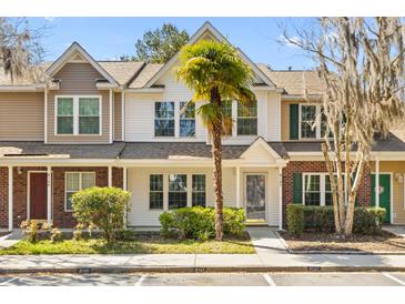 Charming townhome featuring manicured landscaping, a quaint front yard, and a welcoming entryway at 8147 Shadow Oak Dr, North Charleston, SC 29406