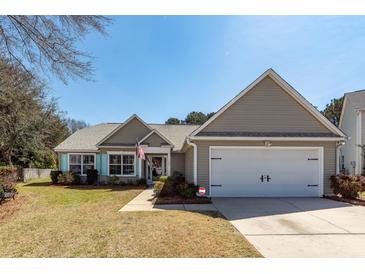 Charming one-story home with a two-car garage, landscaped front yard, and inviting curb appeal at 1233 Bridgeport Dr, Mount Pleasant, SC 29466