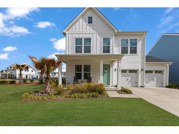 Charming two-story home features a manicured lawn, two-car garage, and a welcoming front porch at 1530 Homecoming Blvd, Ravenel, SC 29470