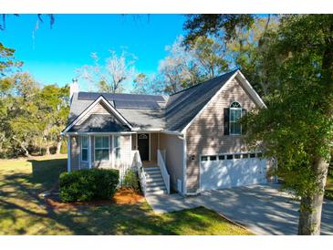 Charming home with solar panels, a two-car garage, and manicured landscaping, offering energy efficiency and curb appeal at 1810 Laura Creek Rd, Charleston, SC 29412
